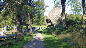 Vid denna jättelika sten ligger Mac Olsson till vänster (ej dansband i detta fall). Bortanför stenen är det en gräsplan och sedan en bit vägvandring